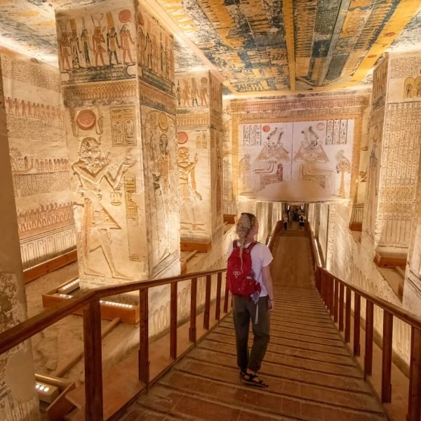 A-stunning-image-of-a-girl-inside-a-tomb-in-the-Valley-of-the-Kings-wearing-a-red-bag